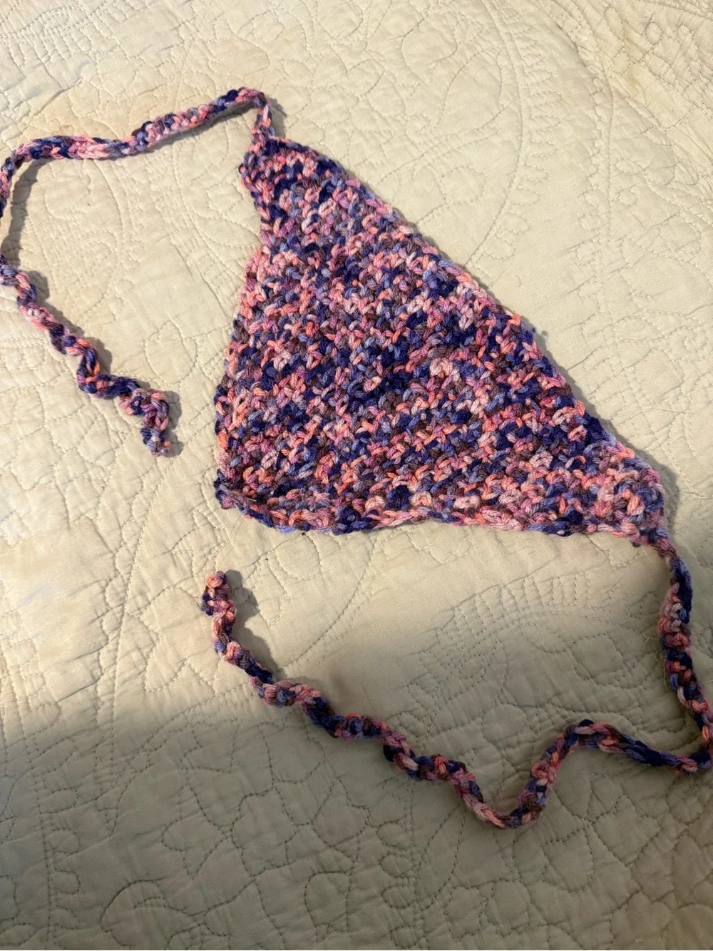 Handmade crochet bandana in pink, blue, and purple marbled yarn.